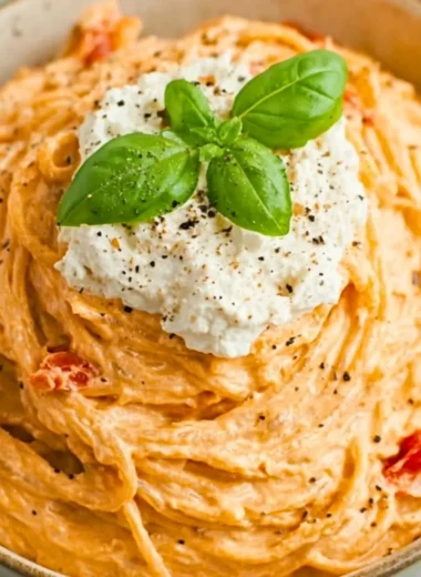 Plate of roasted tomato and garlic ricotta pasta garnished with basil
