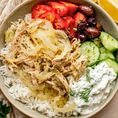 Delicious slow cooker Greek chicken garnished with herbs and lemon slices.