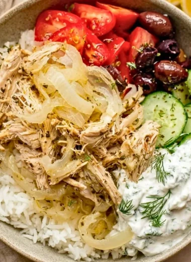 Delicious slow cooker Greek chicken garnished with herbs and lemon slices.