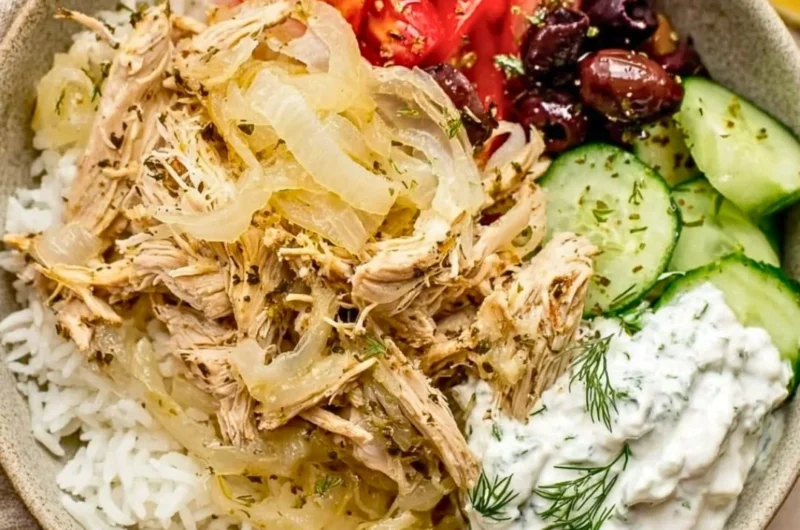 Delicious slow cooker Greek chicken garnished with herbs and lemon slices.