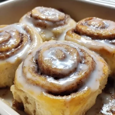 Delicious banana bread cinnamon rolls topped with frosting on a plate