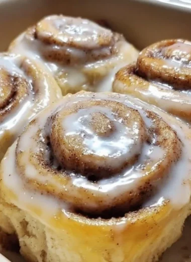 Delicious banana bread cinnamon rolls topped with frosting on a plate