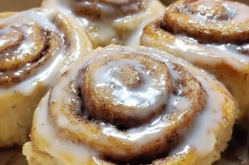 Delicious banana bread cinnamon rolls topped with frosting on a plate