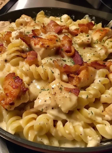A bowl of Chicken Bacon Ranch Pasta topped with parsley and crispy bacon.
