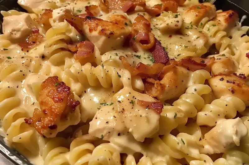 A bowl of Chicken Bacon Ranch Pasta topped with parsley and crispy bacon.