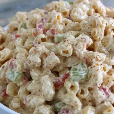Delicious creamy macaroni salad served in a bowl with fresh herbs