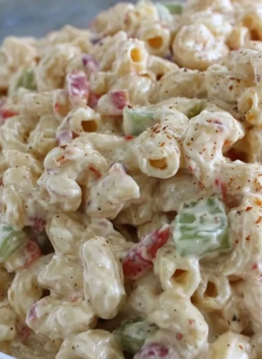 Delicious creamy macaroni salad served in a bowl with fresh herbs