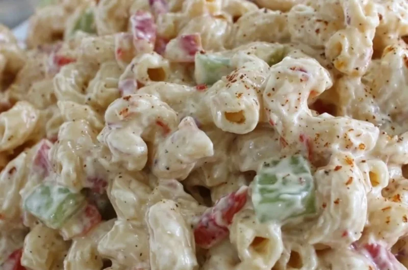 Delicious creamy macaroni salad served in a bowl with fresh herbs