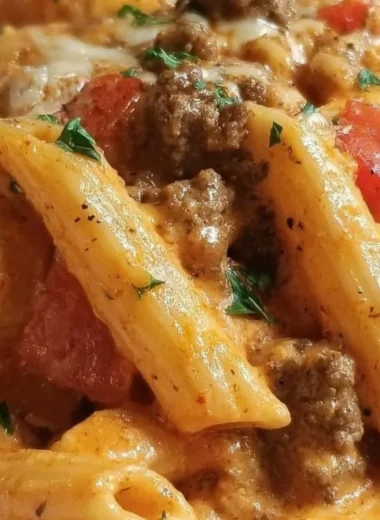 Creamy Rotel pasta dish topped with ground beef and melted cheese