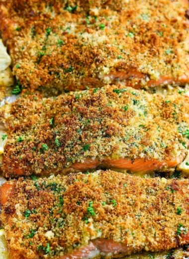 Plate of crispy garlic parmesan salmon garnished with herbs.