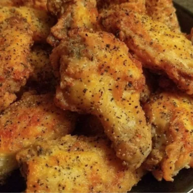 Crispy easy lemon pepper chicken wings garnished with lemon and pepper.