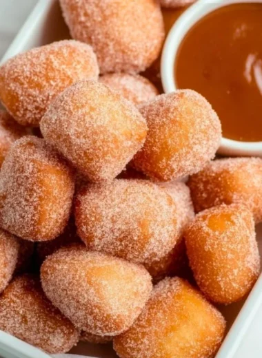Delicious healthy air fryer churro bites on a plate, sprinkled with cinnamon sugar.