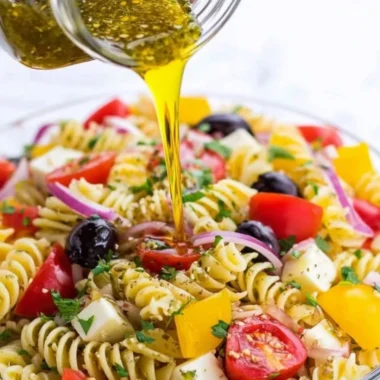A jar of homemade Italian dressing with fresh herbs and spices.