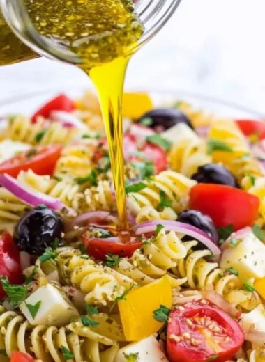 A jar of homemade Italian dressing with fresh herbs and spices.
