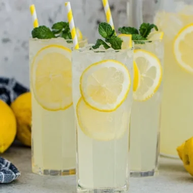 Glass of old-fashioned homemade lemonade with lemon slices and mint leaves