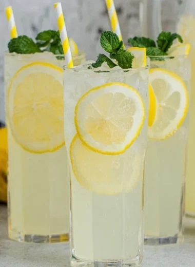 Glass of old-fashioned homemade lemonade with lemon slices and mint leaves