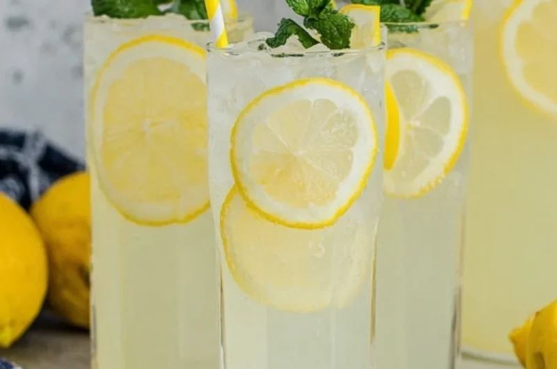 Glass of old-fashioned homemade lemonade with lemon slices and mint leaves