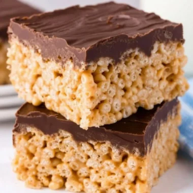 Peanut Butter Rice Krispie Treats on a platter with a decorative background.