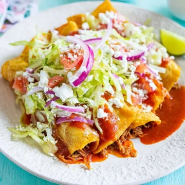 Plate of crispy golden tacos filled with fresh ingredients
