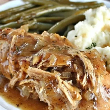 Crock Pot Mississippi Chicken served with sides on a rustic plate.