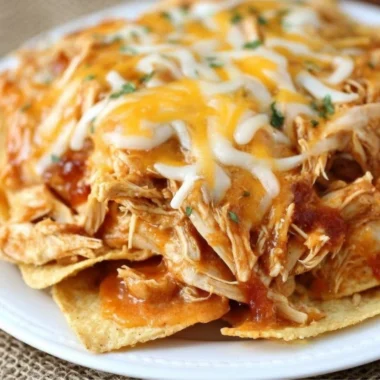 Delicious Crockpot Taco Chicken Nachos garnished with cheese and jalapeños