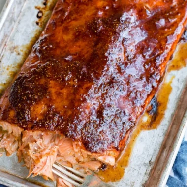 Delicious and easy five ingredient baked salmon on a plate garnished with herbs