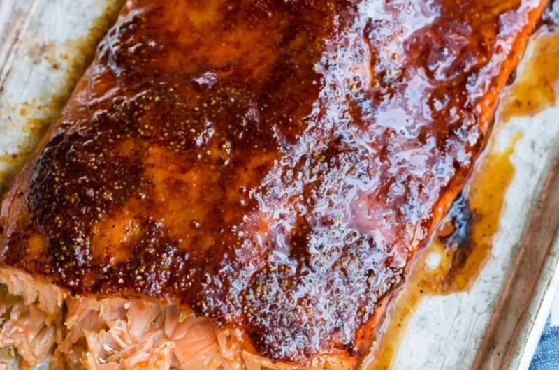 Delicious and easy five ingredient baked salmon on a plate garnished with herbs
