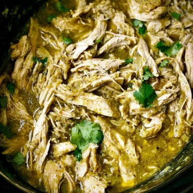 Delicious green sauce crockpot chicken served with fresh herbs.