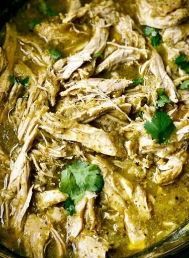 Delicious green sauce crockpot chicken served with fresh herbs.