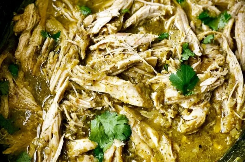 Delicious green sauce crockpot chicken served with fresh herbs.