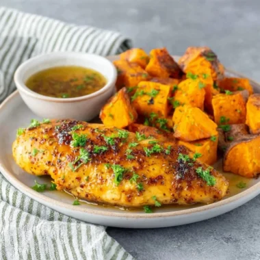 Honey garlic chicken tenders served with fresh vegetables on a plate.