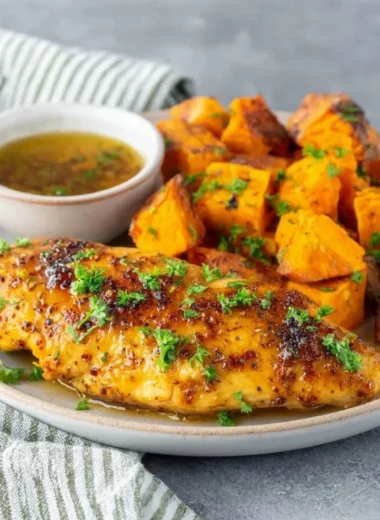 Honey garlic chicken tenders served with fresh vegetables on a plate.