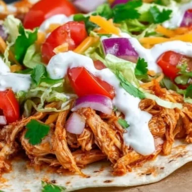 Delicious Mexican Pulled Chicken served in tacos with fresh toppings