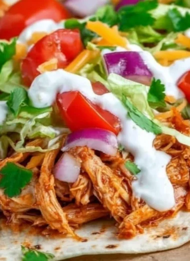 Delicious Mexican Pulled Chicken served in tacos with fresh toppings