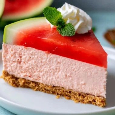 Delicious no-bake watermelon cheesecake garnished with fresh fruit.