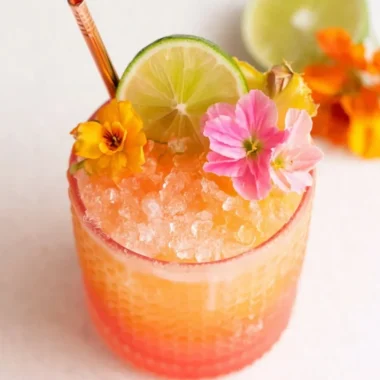 Pineapple mango rum punch in colorful glasses with citrus garnishes