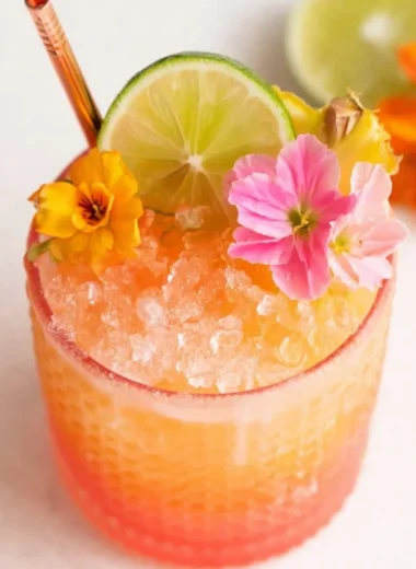 Pineapple mango rum punch in colorful glasses with citrus garnishes