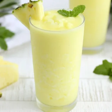 Delicious Pineapple Rum Slush in a glass with tropical garnishes