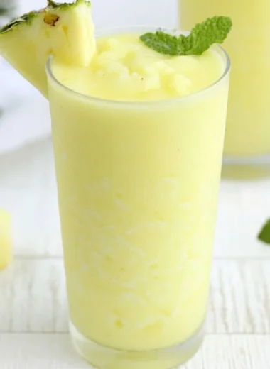 Delicious Pineapple Rum Slush in a glass with tropical garnishes