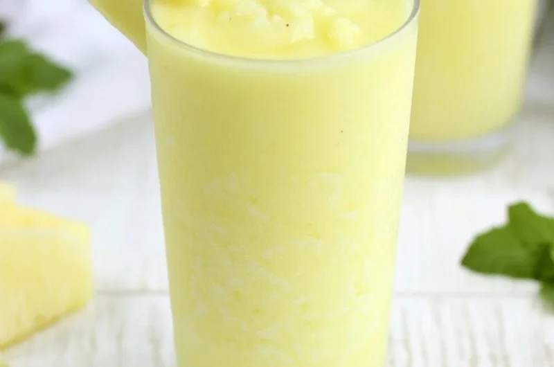 Delicious Pineapple Rum Slush in a glass with tropical garnishes