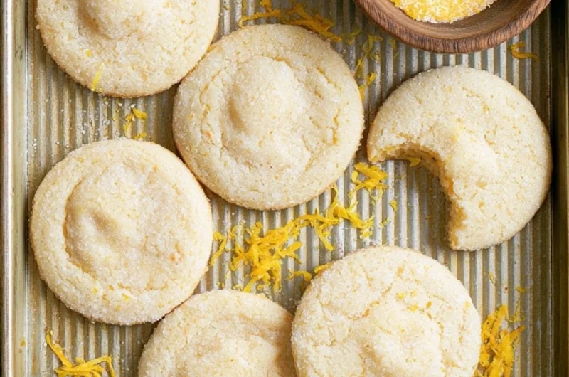 Soft and chewy lemon cookies on a plate with lemon slices