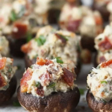 Stuffed mushrooms with bacon and cream cheese garnished with green onions.