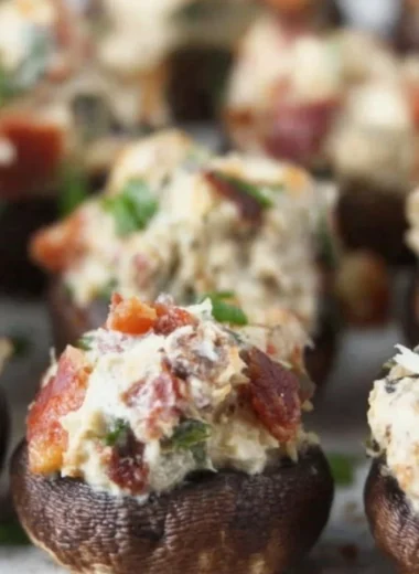 Stuffed mushrooms with bacon and cream cheese garnished with green onions.