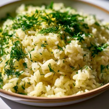 Bowl of authentic Greek lemon rice garnished with parsley and lemon slices