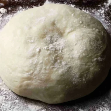 A chef preparing authentic Italian pizza dough from scratch.
