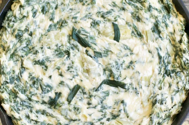 Creamy spinach artichoke dip served in a bowl with fresh vegetables