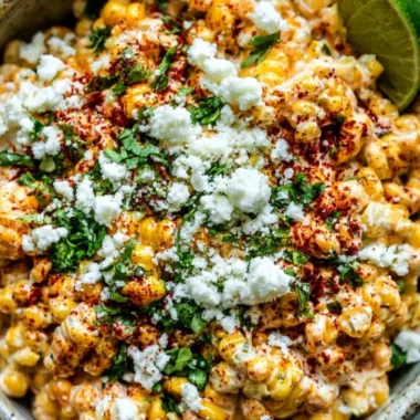 Delicious Mexican Street Corn (Elote) topped with cheese, spices, and lime.