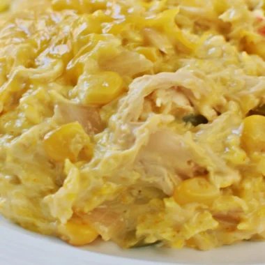 Slow cooker cheesy chicken rice in a bowl with melted cheese and herbs