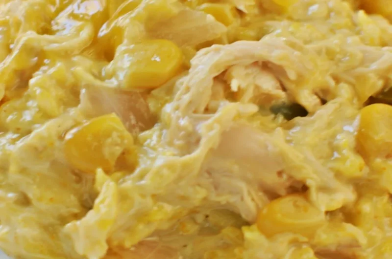 Slow cooker cheesy chicken rice in a bowl with melted cheese and herbs