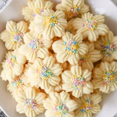 Freshly baked lemon spritz cookies on a baking tray